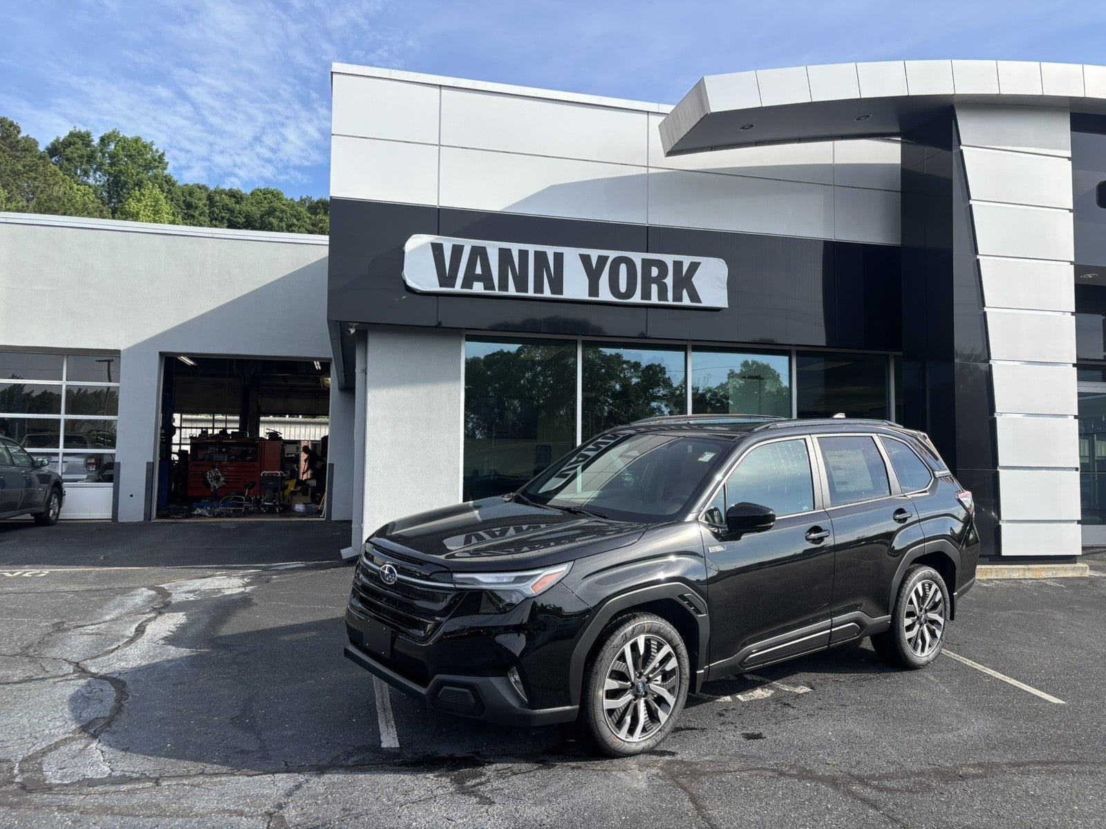 2026 Subaru FORESTER Touring Hybrid in Crystal Black Silica — front three-quarter view